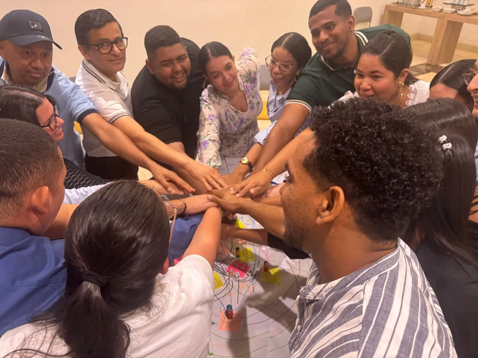 Manos de un equipo unidas al cierre de una sesión con Prama